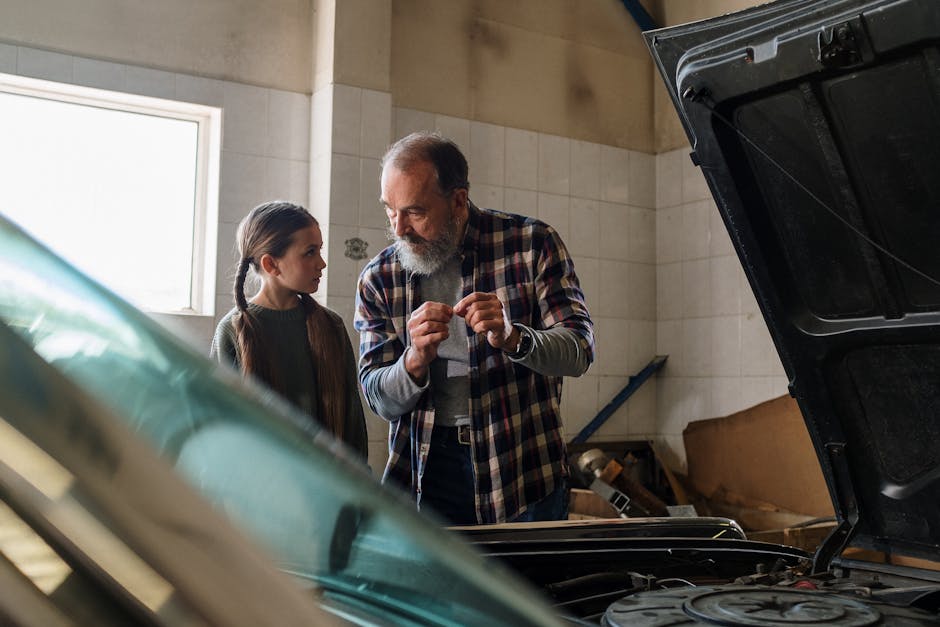 Father and daughter bonding over car repair in a garage workshop.
